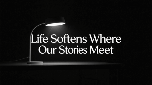 A stylish desk lamp illuminating a quote about stories and life in a dark setting.