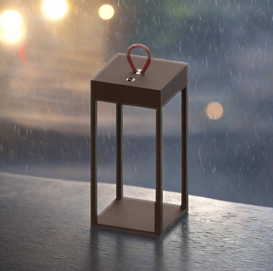Portable rechargeable table lamp with handle, designed for mobility, shown in rain with soft glowing light.