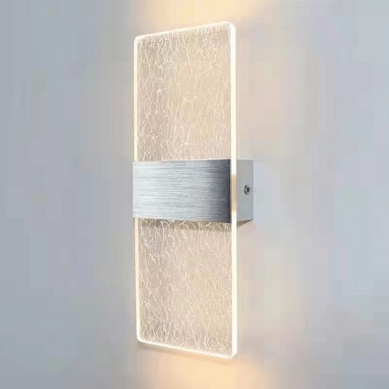Modern LED wall lamp with brushed aluminum base and acrylic shade, ideal for bedroom lighting.