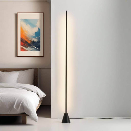 Modern minimalist LED corner floor lamp beside a bed in a stylish bedroom with wall art.