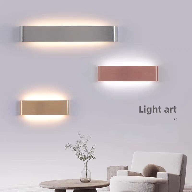 Modern LED strip wall lamps in metallic finishes lighting up a stylish living room with minimalistic decor.